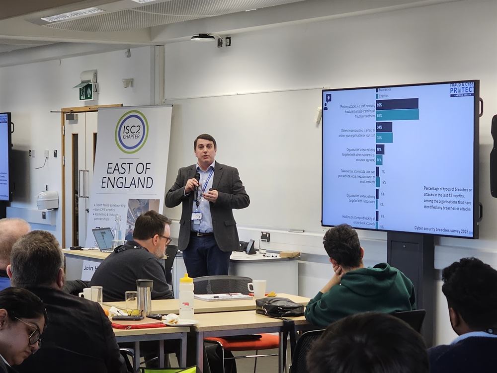 A speaker presenting cyber security breach statistics beside the chapter banner